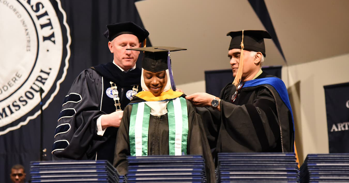 A Lincoln University graduate student receives her hood on commencement day.