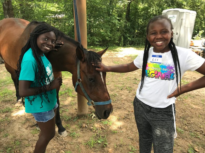 Caruthersville 4-H members groom a horse