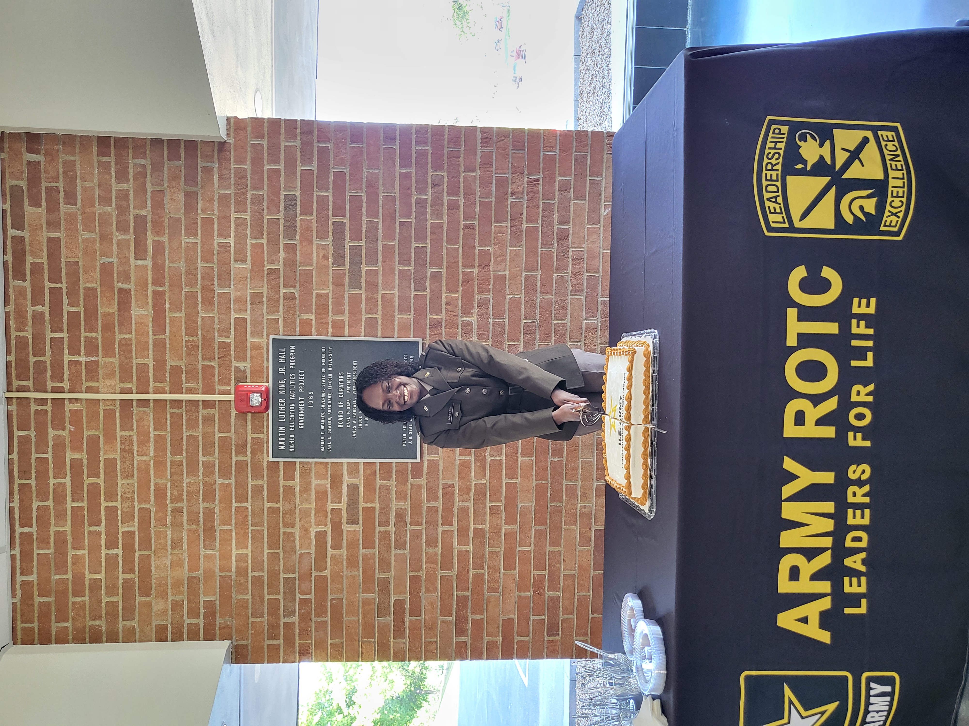 Cadet Kiana Mayers cuts a celebration cake in her honor at the LU ROTC commissioning ceremony.