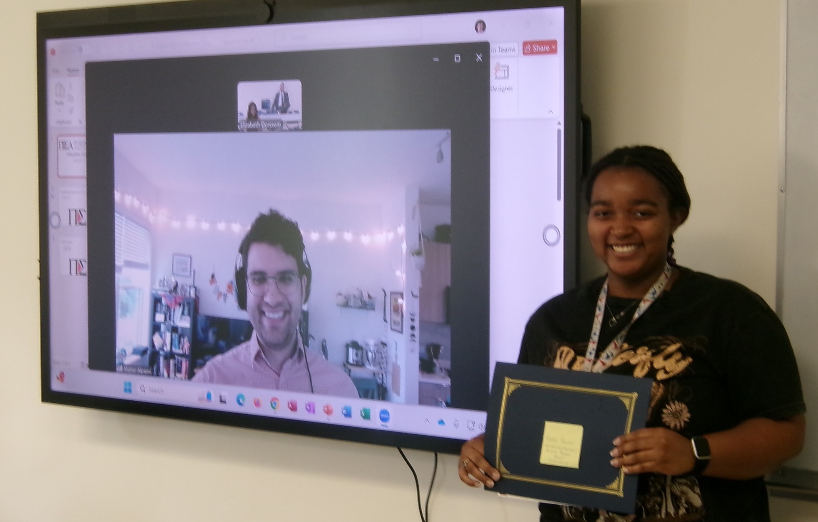 Alpha Zeta Omicron secretary Nia Walker presenting Maher Akremi with the Outstanding LU Political Science Alumni Award.