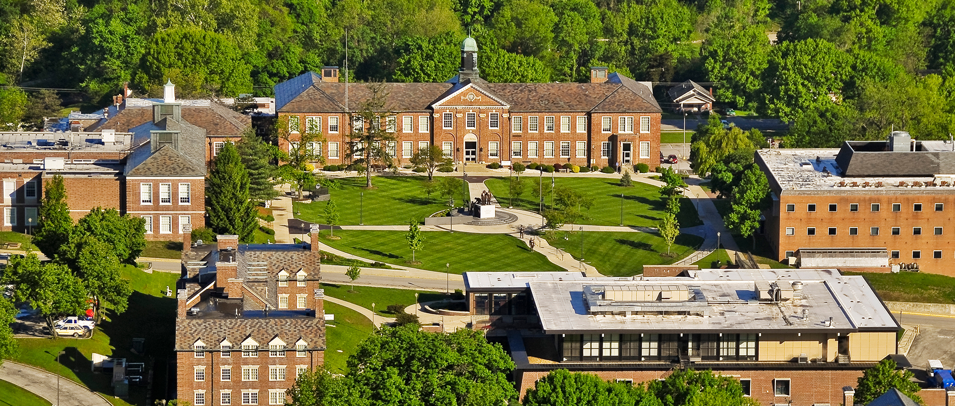 Aerial view of Lincoln University campus featuring historic brick buildings, a central lawn, and surrounding green trees.